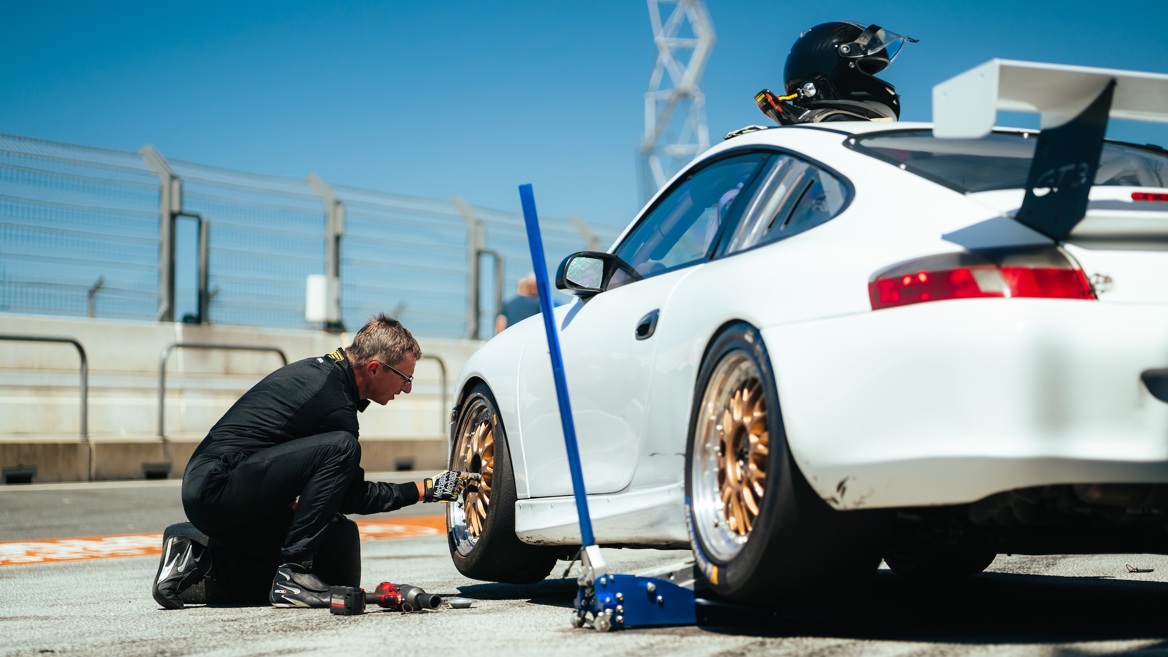 A man changing a car tyre on road